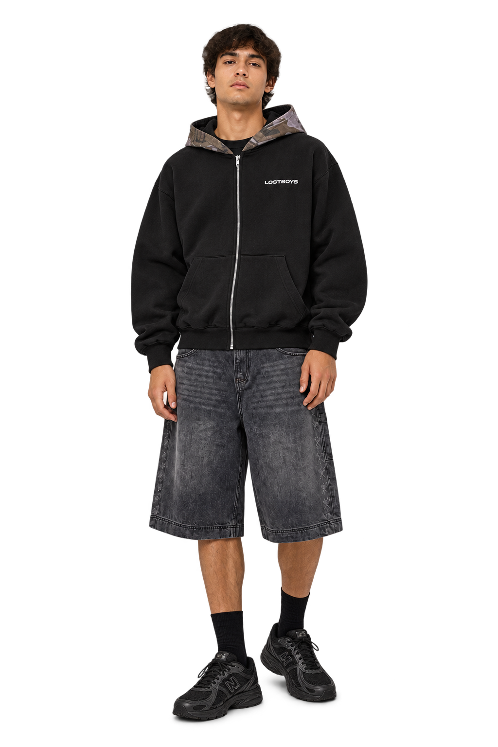 Styled visualization of a black Lost Boys Archives camo zip hoodie, washed-black Godmade denim jorts and black New Balance 740 sneakers